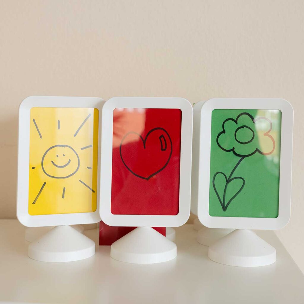 Drei bunte Bilder, die eine Sonne, ein Herz und eine Blume zeigen.